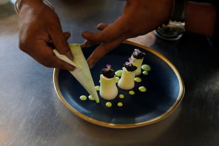 Chef Herilalaina Ravelomanana prepares a plate with Rova caviar at the Marais restaurant in Antananarivo