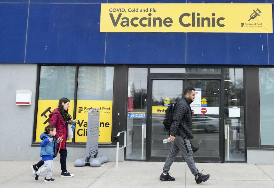 People walk past a vaccine clinic during the COVID-19 pandemic in Mississauga, Ont. in April 2022. THE CANADIAN PRESS/Nathan Denette