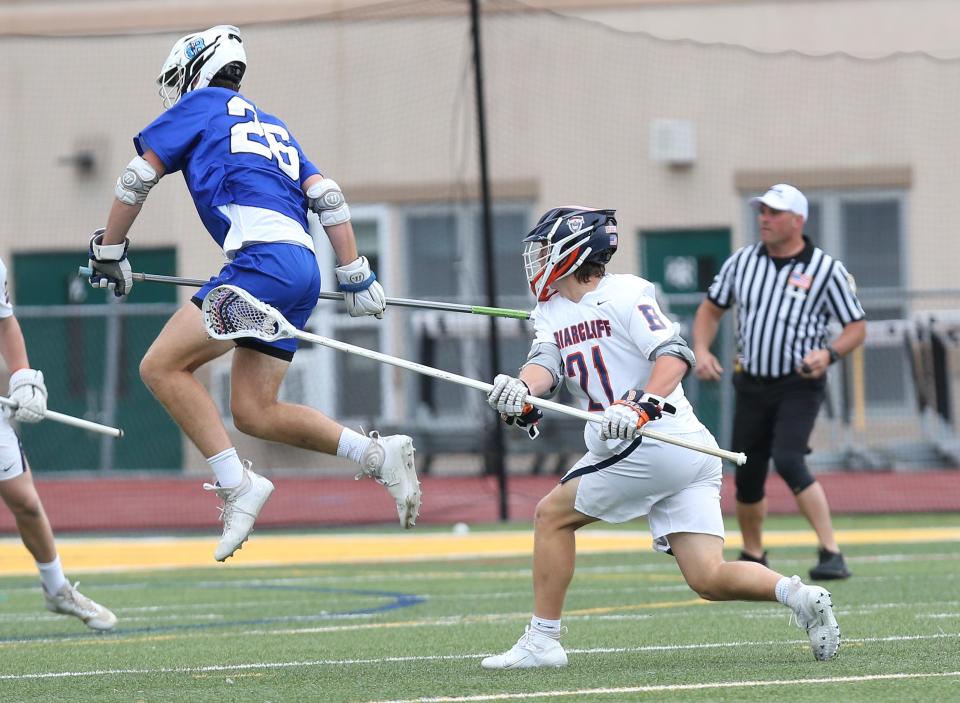 Briarcliff's Timothy Isola (21) fires a shot for a first half goal in front of Bronxville's Preston Maze (26) during the Section 1 Class D championship game at Lakeland High School in Shrub Oak May 27, 2022. Briarcliff won the game 14-4.