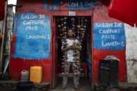 Fabrice, 20, poses in front of his hairdressing salon in Goma, Democratic Republic of Congo, Saturday Nov. 26, 2022.At a time of tension and economic uncertainty, the bold names and brightly colored storefronts bring a sense of normalcy to residents who have contended with conflict and natural disasters such as volcanic eruptions for decades. (AP Photo/Jerome Delay)