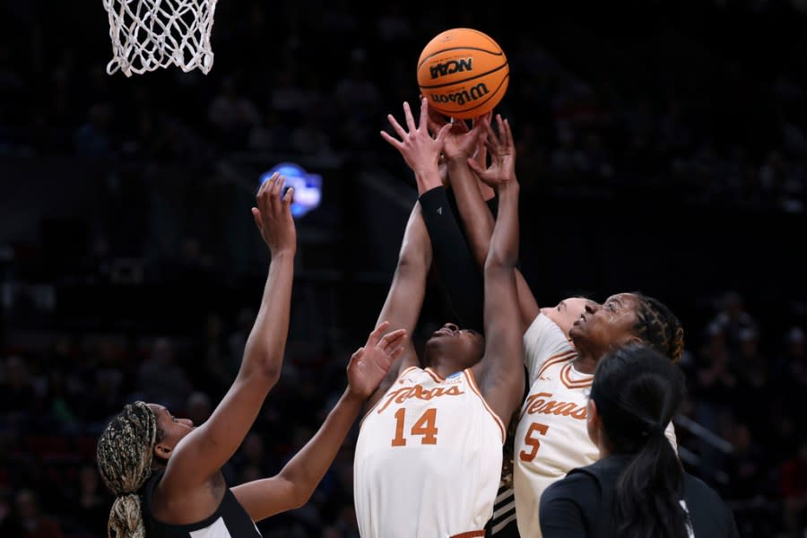 Texas forwards Amina Muhammad (14) and DeYona Gaston (5) and Gonzaga forward Yvonne Ejim, left, try to get a rebound during the second half of a Sweet 16 college basketball game in the women’s NCAA Tournament, Friday, March 29, 2024, in Portland, Ore. (AP Photo/Howard Lao)