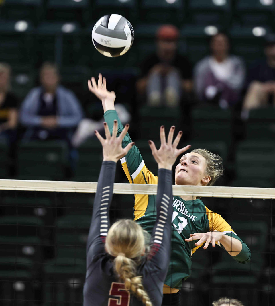 Ursuline Academy's Brooke Bultema (13) goes up for a kill attempt over Bishop Watterson's Ava Hoying (5) during their state semifinal Friday, Nov. 11, 2022.