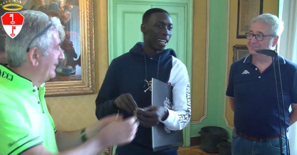 TikTok star Khaby Lame, center, is congratulated by city officials in Chivasso, the northern Italian city where his family settled after leaving Senegal when he was just a year old, after he was granted Italian citizenship on August 17, 2022.  / Credit: Facebook/City of Chivasso