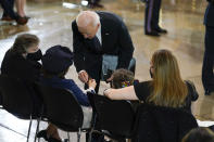 President Joe Biden presents a presidential challenge coin to Logan Evans, son of slain U.S. Capitol Police officer William "Billy" Evans a ceremony at the Capitol in Washington, Tuesday, April 13, 2021. Watching are Abigail Evans, second from right, and mother Shannon Terranova, right. Janice Evans, mother of Billy Evans is at left. (AP Photo/J. Scott Applewhite, Pool)