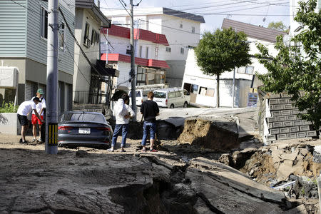 People look at an area damaged by an earthquake in Sapporo in Japan's northern island of Hokkaido, Japan, in this photo taken by Kyodo September 6, 2018. Mandatory credit Kyodo/via REUTERS ATTENTION EDITORS - THIS IMAGE WAS PROVIDED BY A THIRD PARTY. MANDATORY CREDIT. JAPAN OUT. NO COMMERCIAL OR EDITORIAL SALES IN JAPAN.