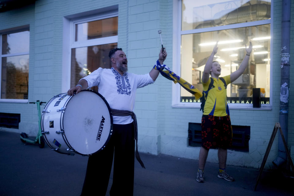 Fans sing before entering a bar to watch the World Cup 2022 qualifying play-off soccer match between Scotland and Ukraine in Kyiv, Ukraine, Wednesday, June 1, 2022. (AP Photo/Natacha Pisarenko)