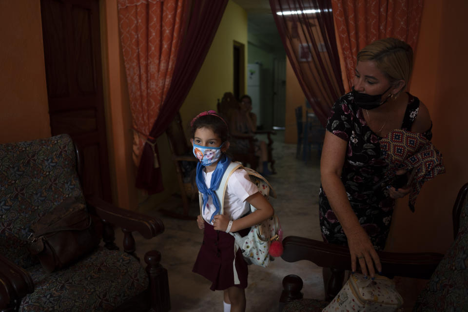 Danmara Triana and her daughter Alice arrive home after picking Alice up from school in Cienfuegos, Cuba, Thursday, May 19, 2022. Triana's husband and son, who is Alice's father and brother, have lived in the U.S. since 2015, while they and another daughter stayed behind in Cuba. (AP Photo/Ramon Espinosa)