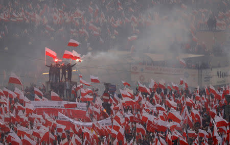 People carry Polish flags and flares during a march marking the 100th anniversary of Polish independence in Warsaw, Poland November 11, 2018. REUTERS/Kacper Pempel