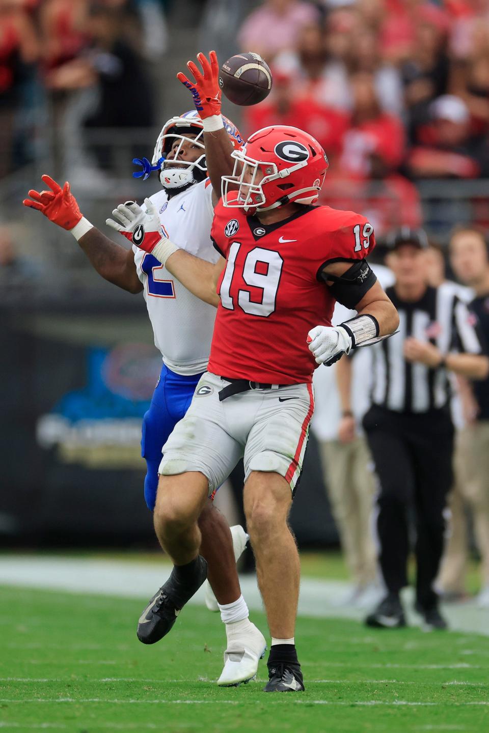 Georgia tight end Brock Bowers reaches back for a batted pass by Florida linebacker Amari Burney. Bowers caught the ball and completed a touchdown in the second quarter of the Bulldogs' 42-20 victory.