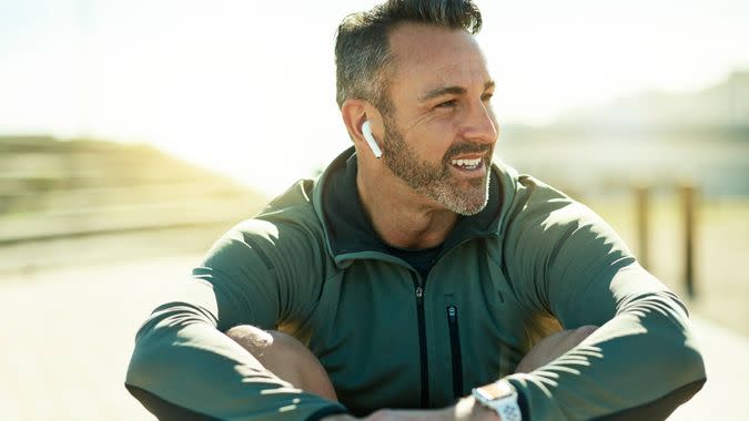 Shot of a mature man using wireless earphones while out for his workout.