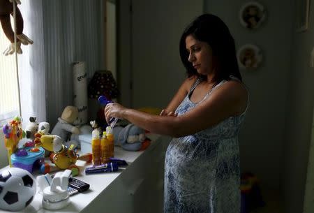 Gisele Felix, who is five months pregnant, applies repellent on her arm at her home in Rio de Janeiro, Brazil, January 28, 2016. Fear of the mosquito-borne Zika virus has Brazilians rushing to buy repellant, creating a shortage of some brands on pharmacy shelves and boosting sales for the industry - a trend some producers are preparing for elsewhere as the outbreak spreads. Picture taken January 28, 2016. REUTERS/Pilar Olivares