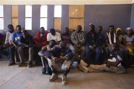 Migrants, who are from different countries in West Africa, sit in the police commissioner's office after being arrested for attempting to bribe a police officer so they could pass a checkpoint without identification in Agadez March 16, 2014. REUTERS/Joe Penney