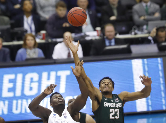 Duke forward Zion Williamson (1) and Michigan State forward Xavier Tillman (23) jump for control of the ball during the opening tip off during the first half of an NCAA men's East Regional final college basketball game in Washington, Sunday, March 31, 2019. (AP Photo}