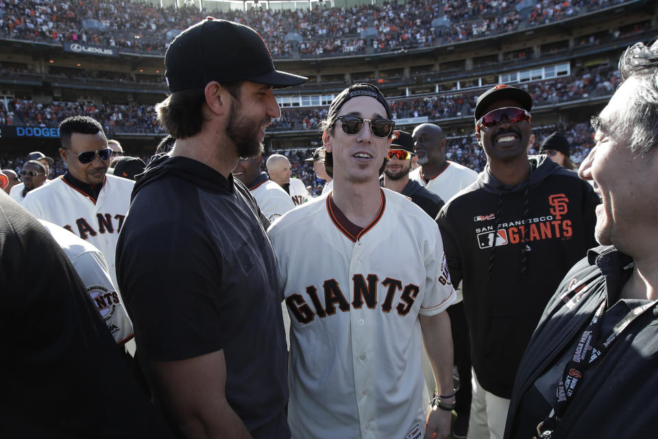 San Francisco Giants pitcher Madison Bumgarner, left, talks with former player Tim Lincecum during a ceremony honoring Giants manager Bruce Bochy after a baseball game between the Giants and the Los Angeles Dodgers in San Francisco, Sunday, Sept. 29, 2019. (AP Photo/Jeff Chiu, Pool)