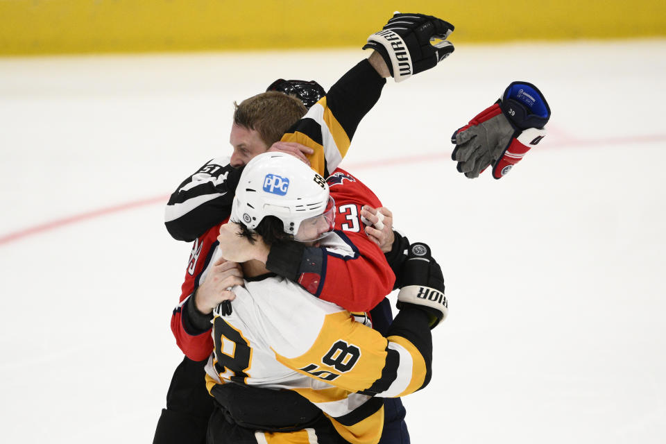 Washington Capitals right wing Anthony Mantha (39) and Pittsburgh Penguins defenseman Kris Letang (58) scuffle during the third period of an NHL hockey game, Thursday, Jan. 26, 2023, in Washington. (AP Photo/Nick Wass)