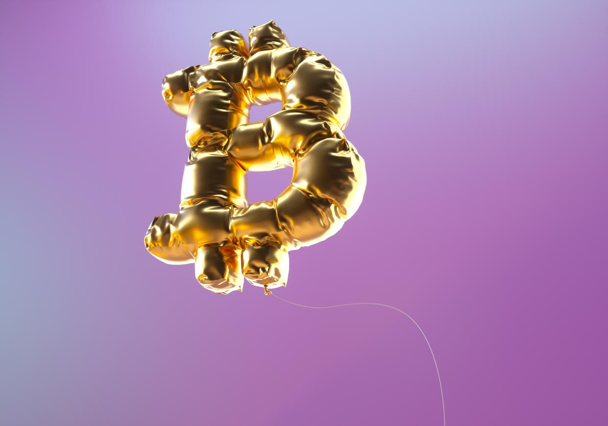 Digital generated image of golden bitcoin sign inflated balloon against purple background.