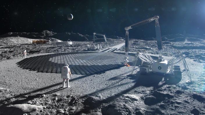     Astronauter observerar gigantiska spindeltranor och 3D-printade landningsplattor på månen. 