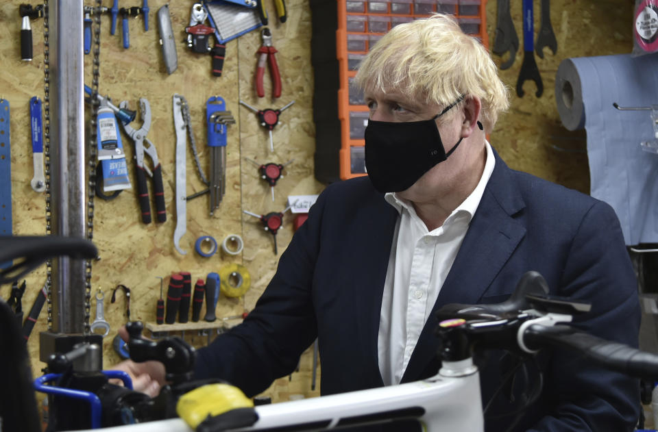 Britain's Prime Minister Boris Johnson talks to the owner of the the Cycle Lounge, Rodney Rouse, a bicycle repair shop Beeston near Nottingham, England, Tuesday, July 28, 2020. The government is launching a new cycling intuitive to help get people fitter. (AP Photo/Rui Vieira, Pool)