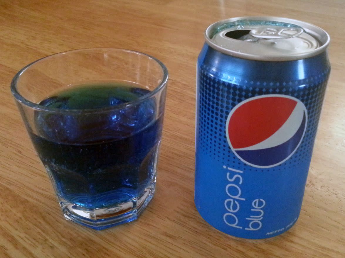 Pepsi Blue can with a plastic cup next to it filled with blue pepsi