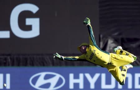 Australia's wicketkeeper Brad Haddin dives but fails to stop a boundary hit by New Zealand's Grant Elliott during their Cricket World Cup final match at the Melbourne Cricket Ground (MCG) March 29, 2015. REUTERS/Jason Reed