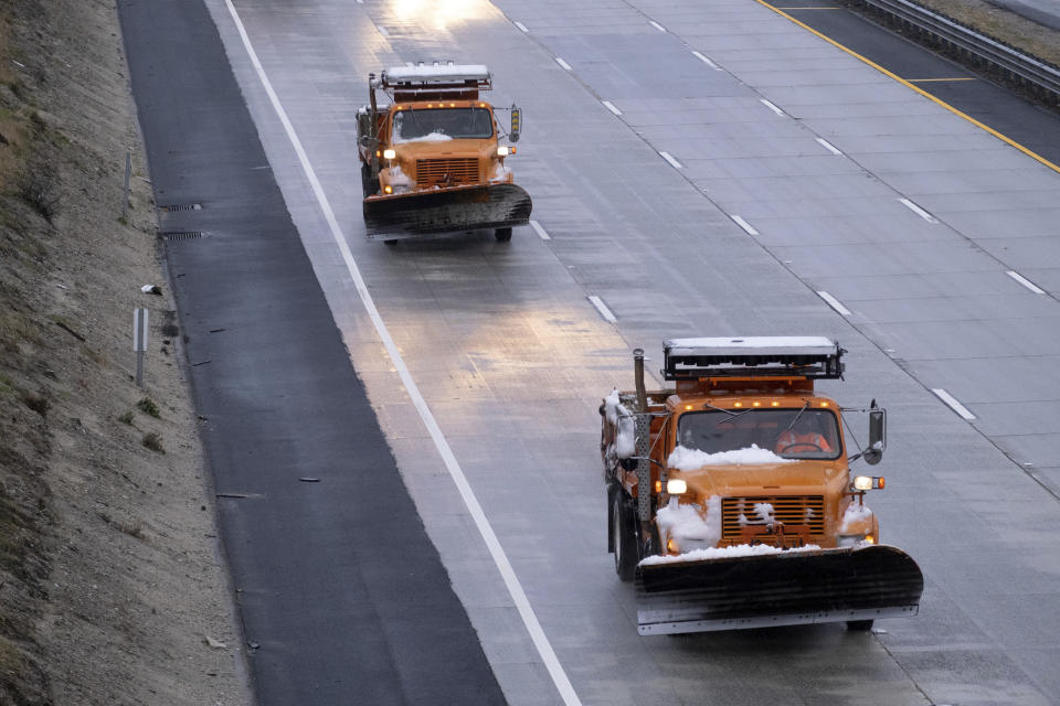 Plows covered with snow return to Castaic, Calif., as snow on the Grapevine closed the freeway Thursday, December 26, 2019. The CHP had no estimate as to when the freeway would re-open. (David Crane/The Orange County Register via AP)