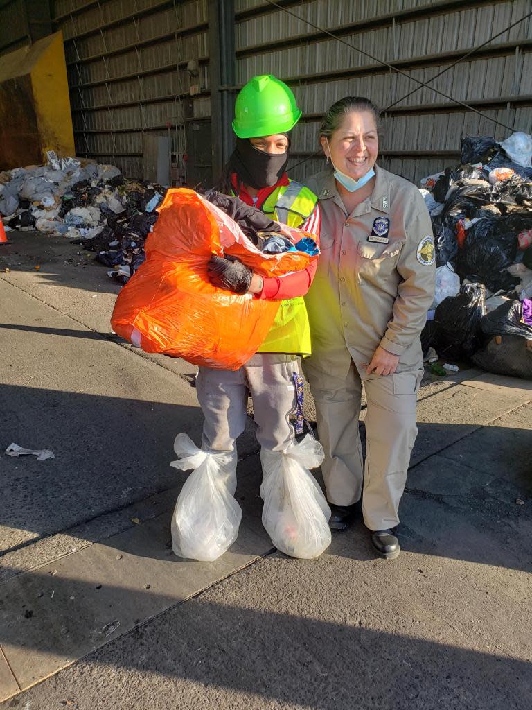 Wearing garbage bags around her feet and legs — the better to wade through the high piles of trash — this woman uncovered a bag of clothing she accidentally put out with the trash. DSNY