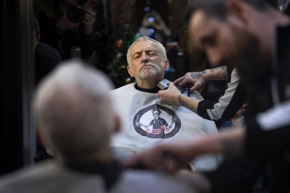 FILE - In this Saturday, Dec. 7, 2019 file photo Labour Party leader Jeremy Corbyn has his beard trimmed in Big Mel's Barbershop, Carmarthen, while on the General Election campaign trail in Wales. (Victoria Jones/PA via AP, File)