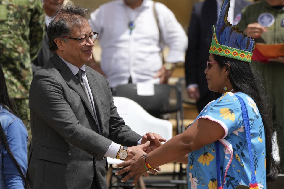 El presidente de Colombia, Gustavo Petro, estrecha las manos con una líder indígena que participó en la búsqueda y rescate de los cuatro niños indígenas que sobrevivieron a un accidente de avioneta y estuvieron perdidos 40 días en las selva colombiana, en una ceremonia en Bogotá, Colombia, el lunes 16 de junio de 2023. (AP Foto/Fernando Vergara)