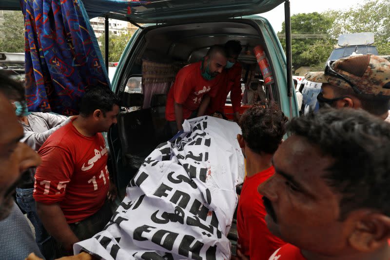 Body of a suspected attacker is removed at the site of an attack outside PSX in Karachi