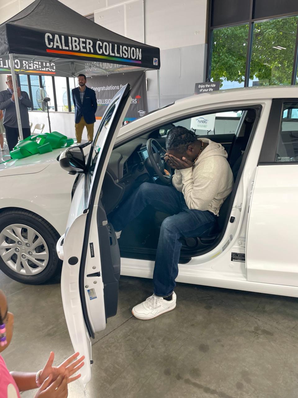 Isaac taylor, a father of six, is overcome with emotion in September 2023 as he receives a car from the National Auto Body Council's Recycled Rides program. Nonprofit Family Promise of Sacramento nominated him to receive a vehicle in April.