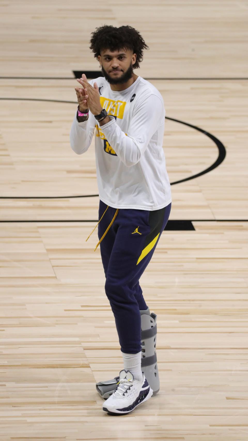 Michigan forward Isaiah Livers, out with a foot injury, walks off the court at the end of the Big Ten tournament semifinal loss to Ohio State, Saturday, March 13, 2021, at Lucas Oil Stadium in Indianapolis.