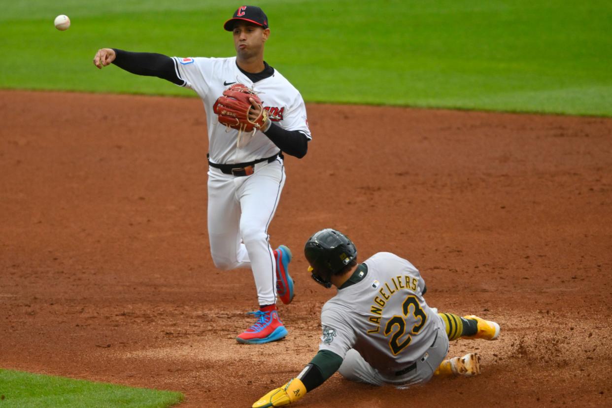 Cleveland Guardians shortstop Brayan Rocchio (4) throws to first base after forcing out Oakland Athletics catcher Shea Langeliers (23) in the second inning Saturday in Cleveland.