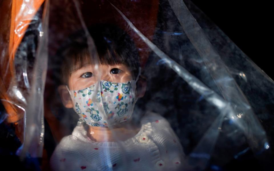 A baby wearing a face mask inside a stroller is seen as the country is hit by an outbreak of the novel coronavirus, in Shanghai - ALY SONG /  REUTERS