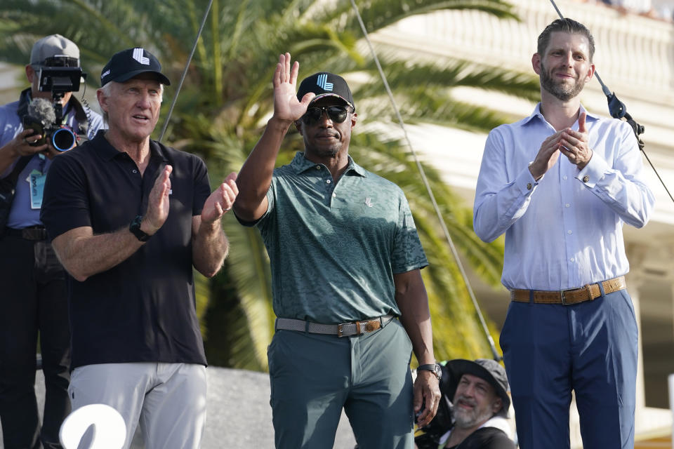Majed Al-Sorour, center, CEO of Golf Saudi, is introduced as LIV Golf CEO Greg Norman, left, and Eric Trump, right, applaud during a ceremony after the final round of the LIV Golf Team Championship at Trump National Doral Golf Club, Sunday, Oct. 30, 2022, in Doral, Fla. (AP Photo/Lynne Sladky)