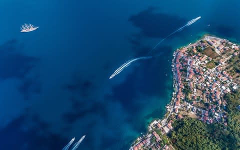 Aerial view of motorboats leaving white trails in Kotor Bay - Credit: iStock