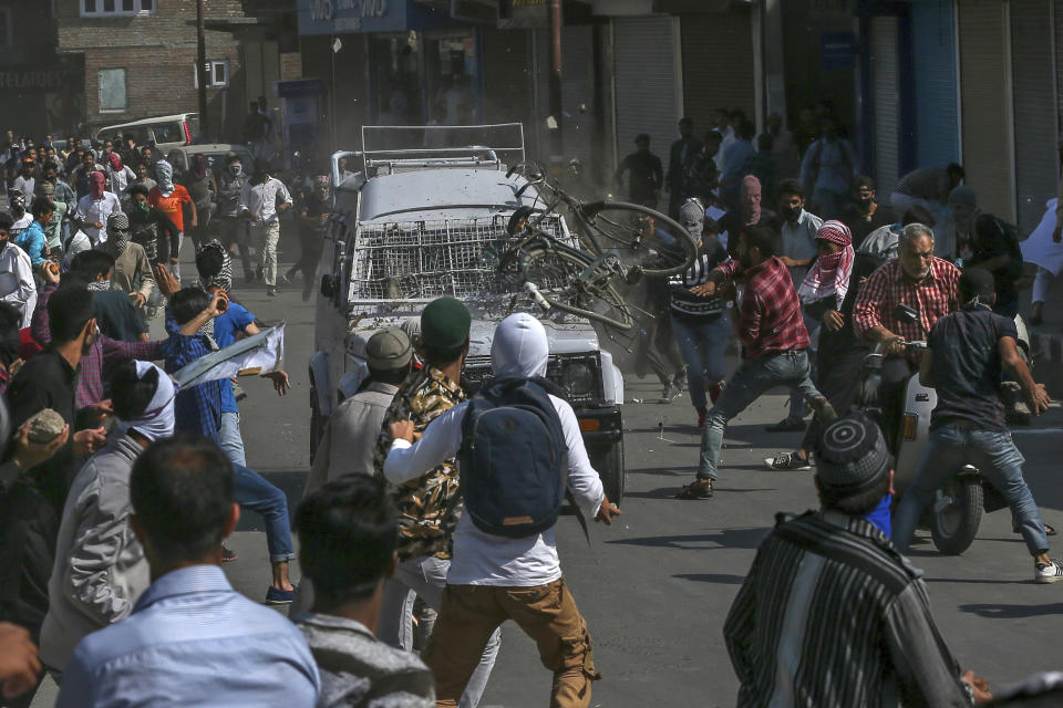 CORRECTS AGE - FILE - In this Friday, June 1, 2018, file photo, Kashmiri Protesters attack an Indian paramilitary vehicle in Srinagar, Indian controlled Kashmir. The death of top separatist leader Syed Ali Geelani on Sept. 1, 2021, in disputed Kashmir and the ensuing crackdown on public movement and communications by Indian authorities have highlighted the turmoil seething just below the surface in the region. Soon after the 91-year-old's death late Wednesday, authorities quickly clamped down, blocking internet and mobile phone services and restricting public movement out of fear of anti-India protests. (AP Photo/Dar Yasin, File)