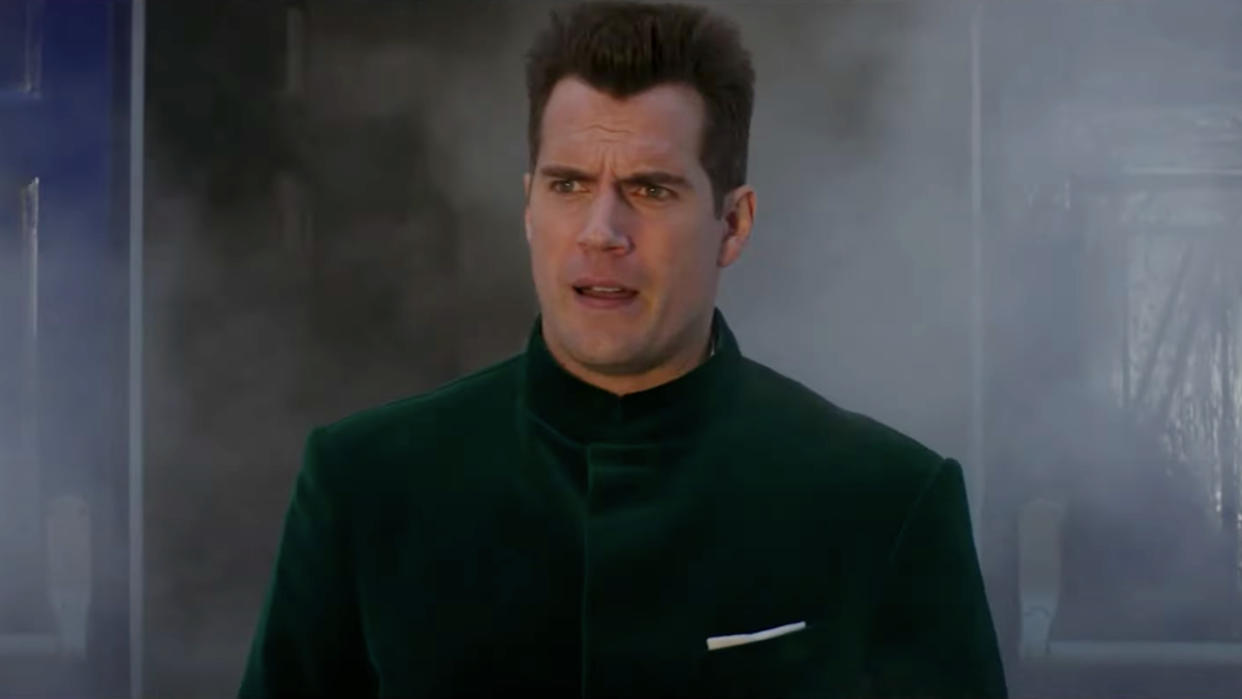  Henry Cavill walks out of smoke in a green velvet jacket in Argylle. 