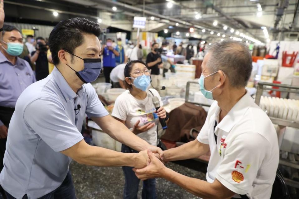 蔣萬安在黨籍議員陪同下至萬華中央魚市場拜會，向攤商承諾當選會加速改建、整頓環境衛生。 （蔣萬安競辦提供）