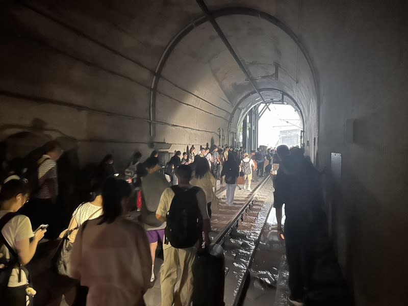 台鐵新自強號今天下午近5時行經花蓮和仁段撞上土石流，列車停在清水隧道內，含司機員共9人輕傷。圖為隧道內乘客依台鐵人員指示等待接駁。（中央社／民眾提供）