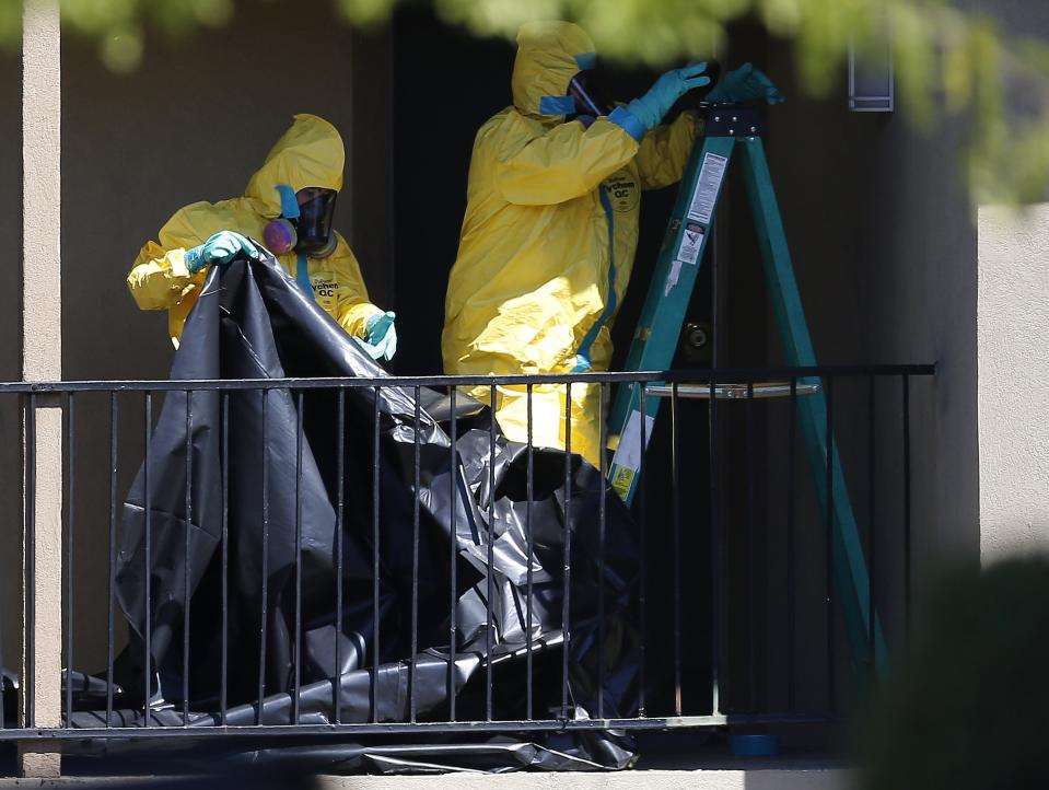 Workers wearing hazardous material suits arrive at the apartment unit where a man diagnosed with the Ebola virus was staying in Dallas, Texas, October 3, 2014. (REUTERS/Jim Young)