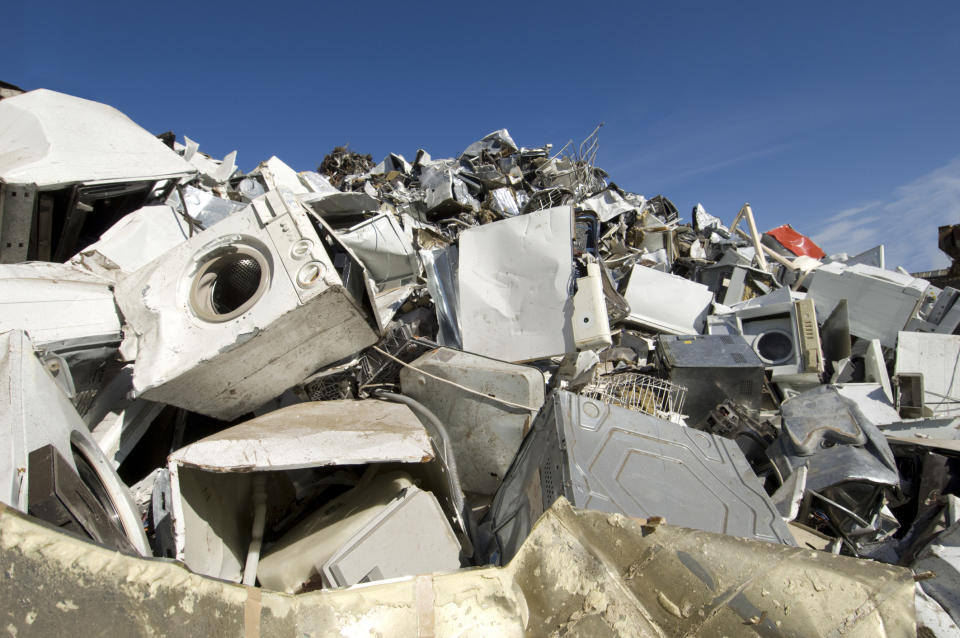 A pile of broken appliances at a junkyard