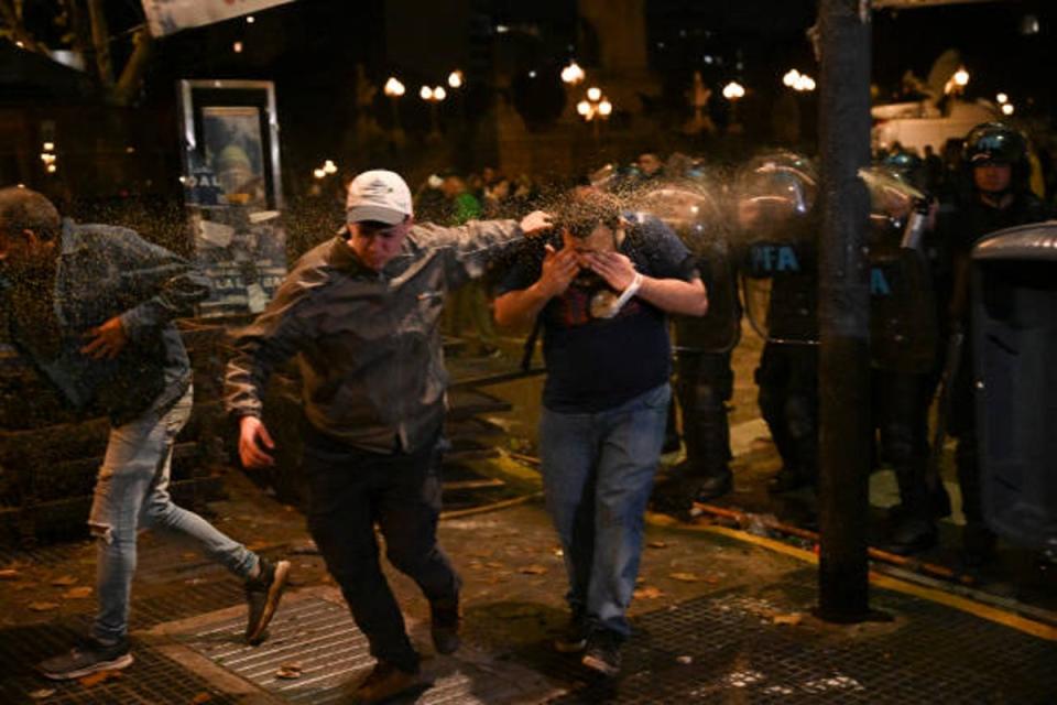 Riot police use pepper-spray on demonstrators during a protest outside the National Congress in Buenos Aires on 12 June 2024 (AFP via Getty Images)