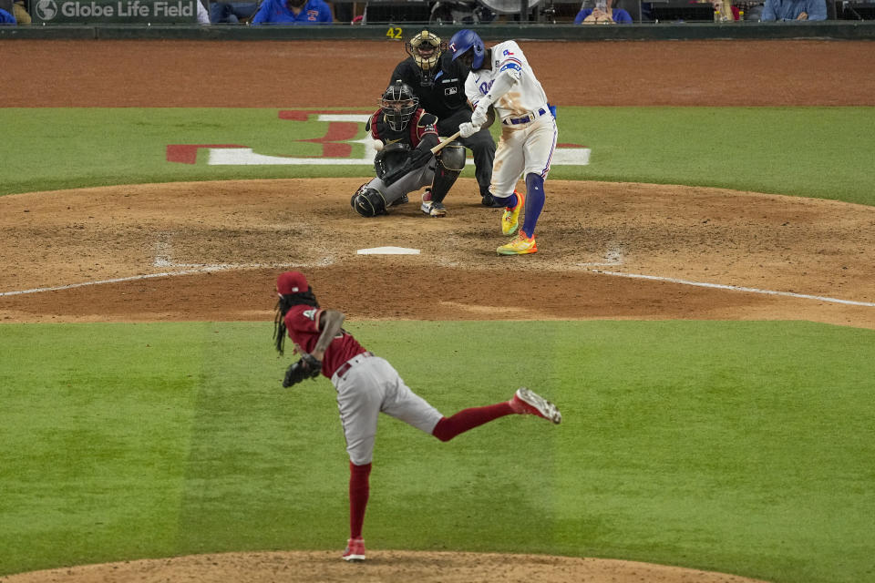 Texas Rangers' Adolis Garcia hits a game-winning home run off Arizona Diamondbacks relief pitcher Miguel Castro during the 11th inning in Game 1 of the baseball World Series Friday, Oct. 27, 2023, in Arlington, Texas. The Rangers won 6-5. (AP Photo/Tony Gutierrez)