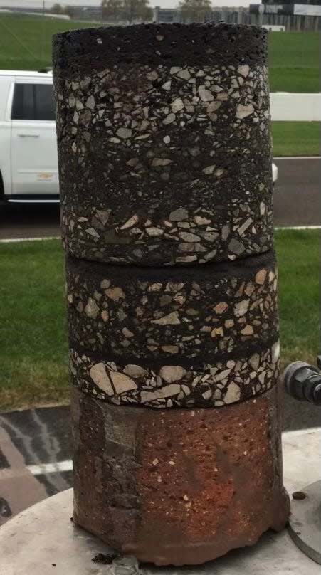 A slice of the Indianapolis Motor Speedway track excavated shows original brick at the bottom with track surfaces that followed stacked on top.