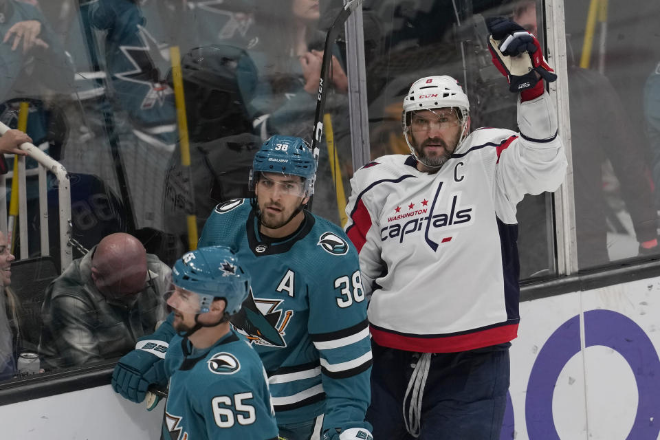 Washington Capitals left wing Alex Ovechkin, right, celebrates after scoring a goal next to San Jose Sharks defenseman Erik Karlsson (65) and defenseman Mario Ferraro (38) during the third period of an NHL hockey game in San Jose, Calif., Saturday, March 4, 2023. (AP Photo/Jeff Chiu)