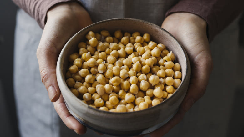 person holding bowl of chickpeas