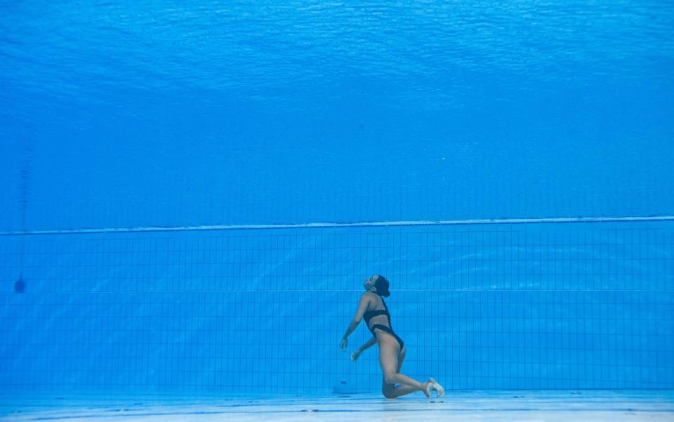 Incredible moment coach dives in to save sychronised swimmer's life after she blacked out and sunk - AFP