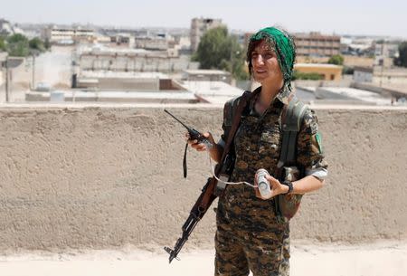 Sheen Ibrahim, Kurdish fighter from the People's Protection Units (YPG) stands on a roof top in Raqqa, Syria June 16, 2017. REUTERS/Goran Tomasevic