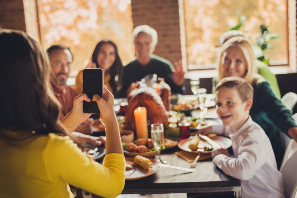 family meeting served table thanksgiving dinner little girl hold telephone