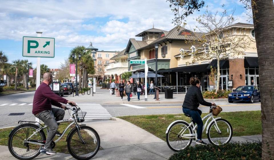 Cyclists ride past the central shopping district in The Market Common community of Myrtle Beach. November 14, 2022.